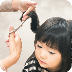 子供の髪の毛をカットしている画像